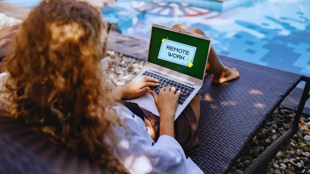 remote work, girls sitting on the fool side table and doing remote work on laptop